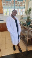 girl in lab coat and black shoes smiling